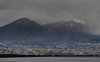 Il vulcano Vesuvio imbiancato dalla prima neve del 2025 visto dal lungomare di Napoli, 12 gennaio 2025. Con il diradarsi delle nubi che avvolgevano il vulcano, è infatti venuto fuori un ampio strato bianco presente non solo sulla cima del monte ma anche lungo gran parte della sua dorsale. Inevitabile l'abbassamento delle temperature, calate rispetto a ieri anche di 6-7 gradi. A livello del mare, invece, continua a insistere una pioggia, a tratti anche intensa, accompagnata da improvvise folate di vento gelido.   ANSA / CIRO FUSCO
///
The Vesuvius volcano stained by the first snow of 2025 seen from the seafront of Naples, Italy, 12 January 2025. With the thinning of the clouds that enveloped the volcano, a wide white layer emerged not only on the top of the mountain but also along much of its ridge. Inevitable the lowering of temperatures, dropped from yesterday even 6-7 degrees. At sea level, however, a rain continues to persist, sometimes even intense, accompanied by sudden bursts of cold wind.   ANSA / CIRO FUSCO