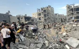 GAZA CITY, GAZA - OCTOBER 31: A screen grab captured from a video shared online shows people conducting search and rescue operation under the debris of a destroyed building as Israeli airstrike continue on the 25th day at Jabalia refugee camp in Gaza City, Gaza on October 31, 2023. (Photo by Fadi Alwhidi/Anadolu via Getty Images)