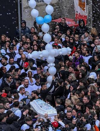 La bara bianca di Arcangelo Correra, il diciottenne ucciso nel centro storico di Napoli dal colpo di pistola sparato per errore da un suo amico, è stata portata a spalla da parenti e amici fino al luogo in cui, all'alba dello scorso 9 novembre, venne ferito a morte, Napoli, 14 novembre 2024. ANSA/CIRO FUSCO