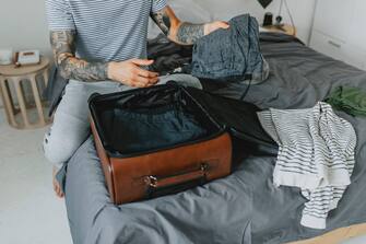 Unrecognizable tattooed man finishing his packing for a short trip outside of the city