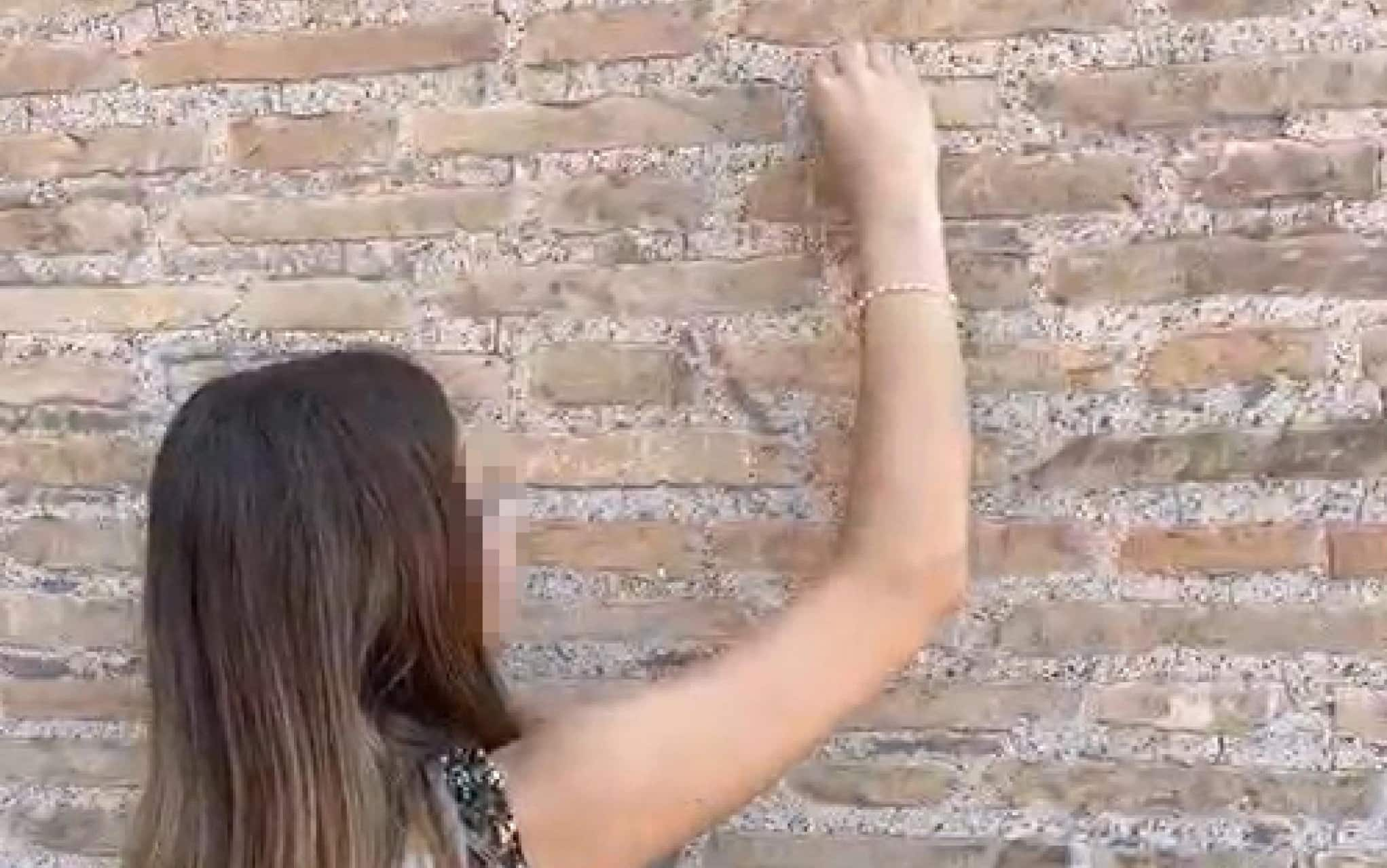 Un frame del video in cui una turista svizzera di 17 incide la lettera iniziale del suo nome su un basamento del Colosseo, li momento è stato ripreso da una guida turistica italiana che ha allertato la vigilanza del parco archeologico, la quale a sua volta ha chiamato i carabinieri, Roma, 14 luglio 2023. La minore, che è in vacanza con la famiglia nella capitale, è stata denunciata dopo essere stata portata nella caserma del comando carabinieri di piazza Venezia e dovrà inoltre rispondere dell'accusa di violazione del regolamento di polizia urbana, che prevede il divieto di imbrattare, disegnare, incidere o compromettere il patrimonio artistico, storico e monumentale della città. 
ANSA
(vandalismo, monumento, simbolica, monumenti, vandalizzati, turista)