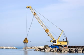 Crawler crane working on the sea shore