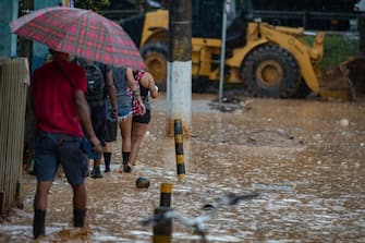 24 February 2023, Brazil, Vila do Sahy: People walk on flooded streets in the village affected by heavy rain in Sao Sebastiao district. The death toll after floods and landslides in Brazil continues to rise. Photo: Andre Lucas/dpa (Photo by Andre Lucas/picture alliance via Getty Images)