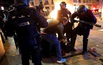 TOPSHOT - A demonstrator is arrested by members of the police forces during a protest called by far-right and right-wing movements against government negotiations for granting an amnesty to people involved with Catalonia's failed 2017 independence bid, near to the Spanish Socialist Party (PSOE) headquarters in Madrid, on November 9, 2023. For the las few days thousands of right-wingers and far-right demonstrators have gathered outside the Socialist Party headquarters in Madrid in tense protests against the government's proposed law granting amnesty to Catalan separatists. Spanish Prime Minister Pedro Sanchez has clinched a controversial deal to remain in power by offering amnesty to Catalan separatists, raising tensions across the country. The accord is aimed at "giving stability to the four-year legislature," Spanish Socialist Party (PSOE) official Santos Cerdan told a news conference in Brussels today after negotiations with Catalan separatist leader Carles Puigdemont, who is based there. (Photo by Pierre-Philippe MARCOU / AFP) (Photo by PIERRE-PHILIPPE MARCOU/AFP via Getty Images)