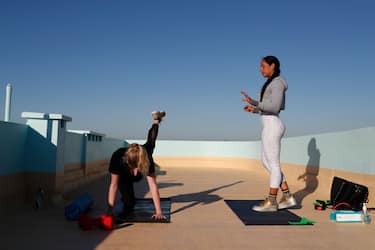 SYDNEY, AUSTRALIA - APRIL 14: Personal trainer Ana Coppola (R) conducts a personal training session on the sectioned off rooftop of her clients North Bondi  rooftop on April 14, 2020 in Sydney, Australia. With strict measures in place due to COVID-19, personal trainers are adapting the way they work in order to comply with current government social distancing requirements. (Photo by Don Arnold/Getty Images)
