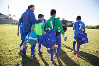 Boys soccer team, aged 12-14, leaving after a game with their coach