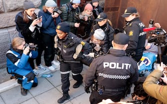 Policewomen carry away Swedish climate activist Greta Thunberg (C) as she demonstrated with other campaigners outside the Ministry of Finance and several other ministries on March 1, 2023 in Oslo, Norway, to protest against wind turbines built on land traditionally used to herd reindeer. - Thunberg and dozens of indigenous Sami activists were forcibly removed by police as they continued to block access to Norwegian ministries protesting against the operation of contested wind turbines in the Fosen region of western Norway, more than a year after a landmark ruling by the Norwegian Supreme Court. (Photo by Alf SIMENSEN / NTB / AFP) / Norway OUT (Photo by ALF SIMENSEN/NTB/AFP via Getty Images)