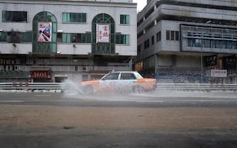 A taxi drives along a flooded road in Hong Kong on September 8, 2023. Record rainfall in Hong Kong caused widespread flooding in the early hours on September 8, disrupting road and rail traffic just days after the city dodged major damage from a super typhoon. (Photo by Bertha WANG / AFP) (Photo by BERTHA WANG/AFP via Getty Images)
