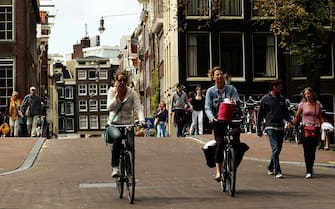 AMSTERDAM, NETHERLANDS - MAY 11:  Cyclists make their way through the city streets on May 11, 2009 in Amsterdam, Netherlands. The 750,000 people who live in Amsterdam own over 600,000 bicycles.  (Photo by Mark Dadswell/Getty Images)