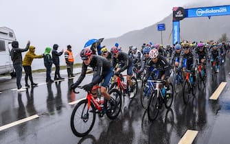 epa10640573 Cyclists cross in the rain the Simplon Pass during the 14th stage of the 2023 Giro d'Italia cycling race over 194 km from Sierre to Cassano Magnago, Switzerland, 20 May 2023.  EPA/JEAN-CHRISTOPHE BOTT