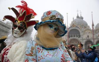 Due personaggi, vestiti di costumi di fantasia,  posano in piazza San Marco, per il carnevale veneziano, oggi 18 febbraio 2023. ANSA/ANDREA MEROLA                               