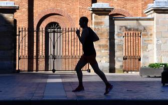 epa08519938 A person jogging at a street in Sydney's central business district (CBD) as the New South Wales Government eases further restrictions following coronavirus disease (COVID-19) lockdown measures, Sydney, New South Wales (NSW), 01 July 2020. NSW recorded three new COVID-19 cases this week.  EPA/DEAN LEWINS  AUSTRALIA AND NEW ZEALAND OUT