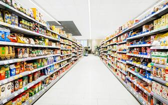 A colorful supermarket aisle withe no people but an abundance of food.