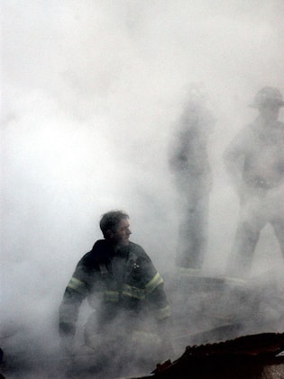 Torri gemelle NEW YORK, NY - SEPTEMBER 14: This US Navy photo released 17 September, 2001, shows a firefighter emerging from the smoke and debris of the World Trade Center 14 September, 2001. The twin towers of the center were destroyed in a September 11 terrorist attack. (Photo credit should read JIM WATSON/AFP via Getty Images)