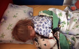 Un bambino a letto sotto le coperte