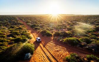 Australia, red sand unpaved road and 4x4 at sunset, Francoise Peron, Shark Bay.
