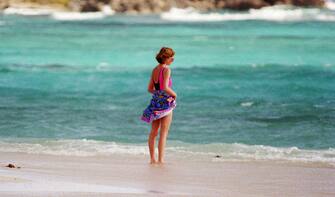 NECKER ISLAND, BRITISH VIRGIN ISLANDS - JANUARY 09: Diana, Princess of Wales, wearing a pink and black swimming costume, sunglasses and a sarong tied round her waist, stands alone on the beach while holidaying on Necker Island on January 9, 1989 in the British Virgin Islands. (Photo by Anwar Hussein/WireImage)