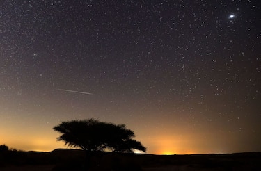 TOPSHOT - A Perseid meteor streaks across the sky above the Negev desert near the Israeli city of Mitzpe Ramon, on August 12, 2021, during a yearly meteor shower, which occurs when the earth passes through the cloud of debris left by the comet Swift-Tuttle. (Photo by Menahem KAHANA / AFP) (Photo by MENAHEM KAHANA/AFP via Getty Images)