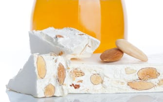 Sweet nougat with almonds on white background