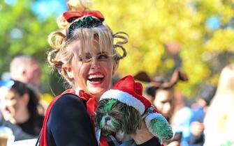 NEW YORK, NEW YORK - OCTOBER 22: A woman and her god dressed as The Grinch and Santa participate in the 32nd Annual Tompkins Square Halloween Dog Parade on October 22, 2022 in New York City. The parade returned to Tompkins Square Park after being relocated last year.  (Photo by Alexi Rosenfeld/Getty Images)
