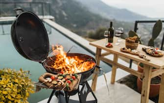 Outside terrace with pool. Fireplace for cooking, party with barbecue and wine. Cooking vegetarian meal with natural and organic vegetables marinated in spices. Grilled tasty snack. No people, copy space background.