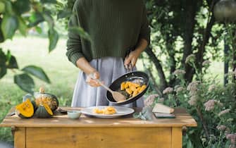 Young woman with homemade pumpkin gnocchi, partial view