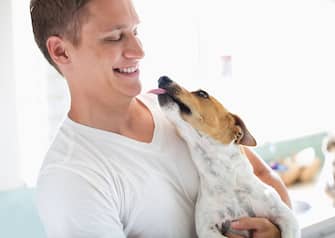 Smiling man holding dog
