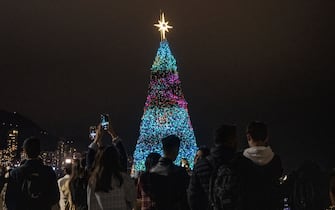 People are taking photos of a Christmas tree in Hong Kong, China, on December 16, 2023. (Photo by Vernon Yuen/NurPhoto via Getty Images)