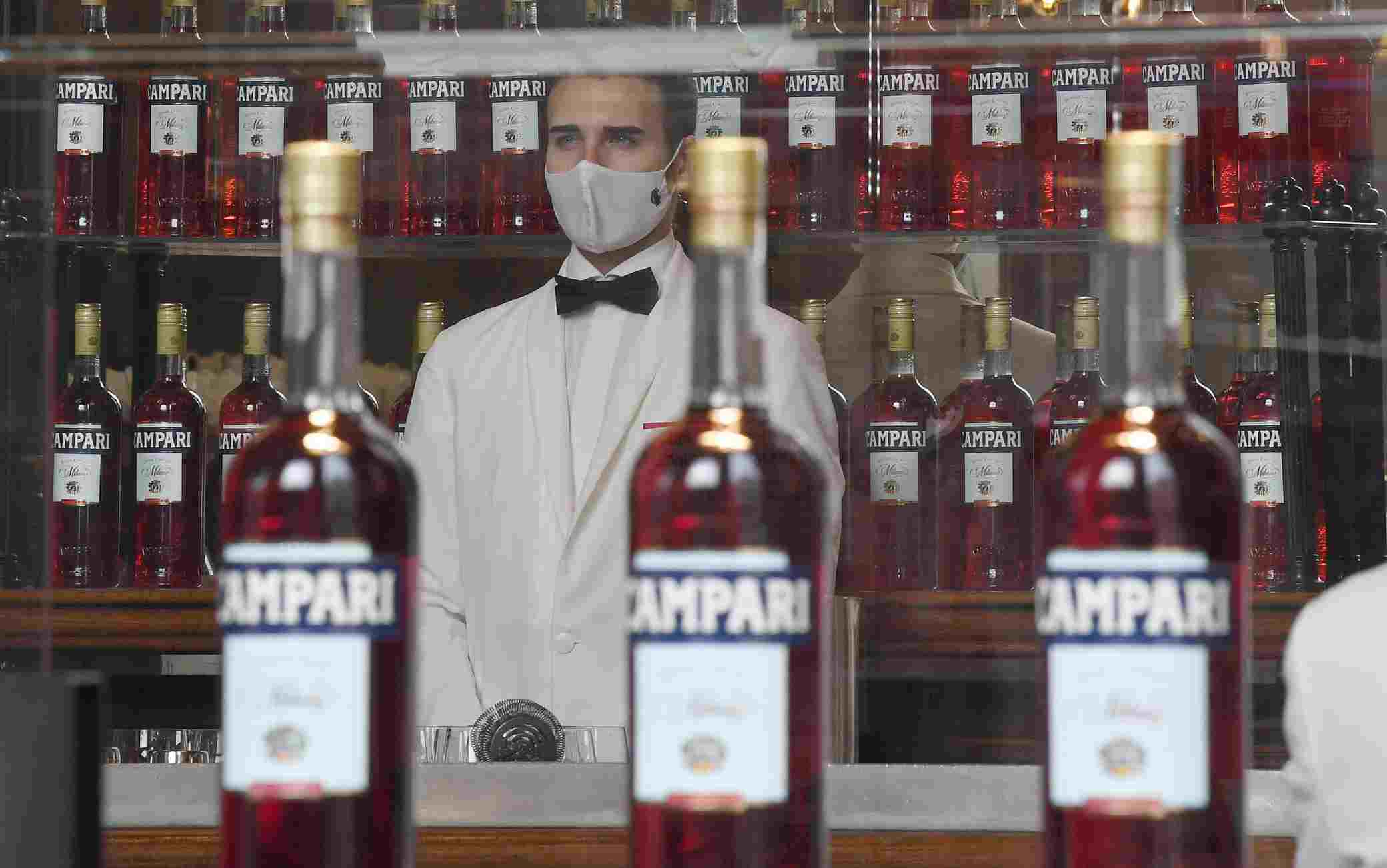 Bottiglie di Campari esposte sulla vetrina del bar Camparino in Galleria Vittorio Emanuele, Milano, 18 febbraio 2020.  Campari ha chiuso il 2020 con vendite nette per 1.772 milioni di euro, in calo del 3,8% sul 2019 (-4,1% a livello organico), con una flessione più sostenuta, il 7% a livello organico, nel quarto trimestre per effetto dei nuovi lockdown. L'utile netto, si legge in una nota, si è attestato a 187,9 milioni, in calo del -39,1% dopo rettifiche operative, finanziarie e fiscali per 14,2 milioni senza le quali il calo sarebbe stato contenuto al 24,4%. ANSA/DANIEL DAL ZENNARO