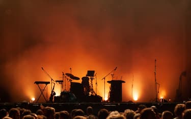 empty concert stage on music festival, instruments silhouettes, microphones drums guitars and crowd of people