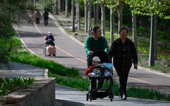 People walk in a public park in Beijing on April 15, 2023. (Photo by WANG Zhao / AFP) (Photo by WANG ZHAO/AFP via Getty Images)