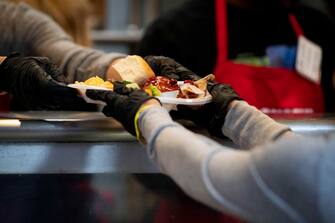 epa08088538 Volunteers serve food to people experiencing homelessness and poverty inside of the Los Angeles Mission homeless shelter during their annual Christmas celebration in the Skid Row district of Los Angeles, California, USA, 23 December 2019.  EPA/CHRISTIAN MONTERROSA