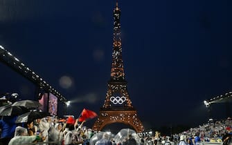 Members of delegations walk on the Iena Bridge during the opening ceremony of the Paris 2024 Olympic Games in Paris on July 26, 2024, as the Eiffel Tower is seen in the background. (Photo by Loic VENANCE / POOL / AFP) (Photo by LOIC VENANCE/POOL/AFP via Getty Images)