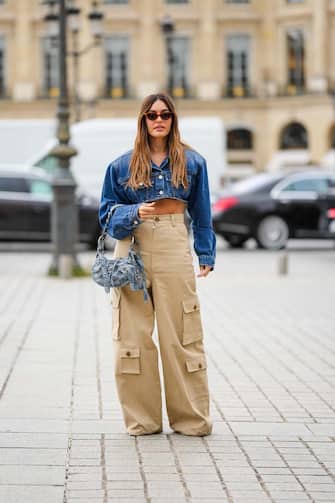PARIS, FRANCE - SEPTEMBER 29: Karen Wazen wears brown cat eyes sunglasses, a navy blue denim oversized / cropped top, a black t-shirt, a  blue and white print pattern denim nailed / studded Cagole handbag from Balenciaga, outside Chloe, during Paris Fashion Week - Womenswear Spring/Summer 2023, on September 29, 2022 in Paris, France. (Photo by Edward Berthelot/Getty Images)