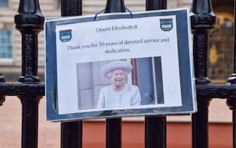 Un cartello in ricordo della Regina affisso sui cancelli di Buckingham Palace