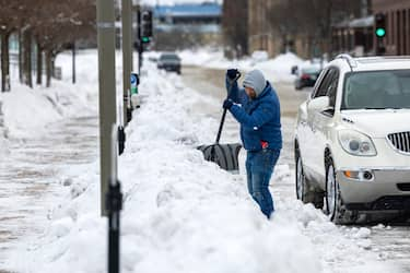 epa11080230 A day laborer shovels snow from the sidewalk in downtown Des Moines, Iowa, USA, 15 January 2024. With temperatures dropping to eight degrees below zero Fahrenheit (minus 22 degrees Celsius), the state may experience lower than usual turnout for its first-in-the-nation presidential caucus.  EPA/JIM LO SCALZO