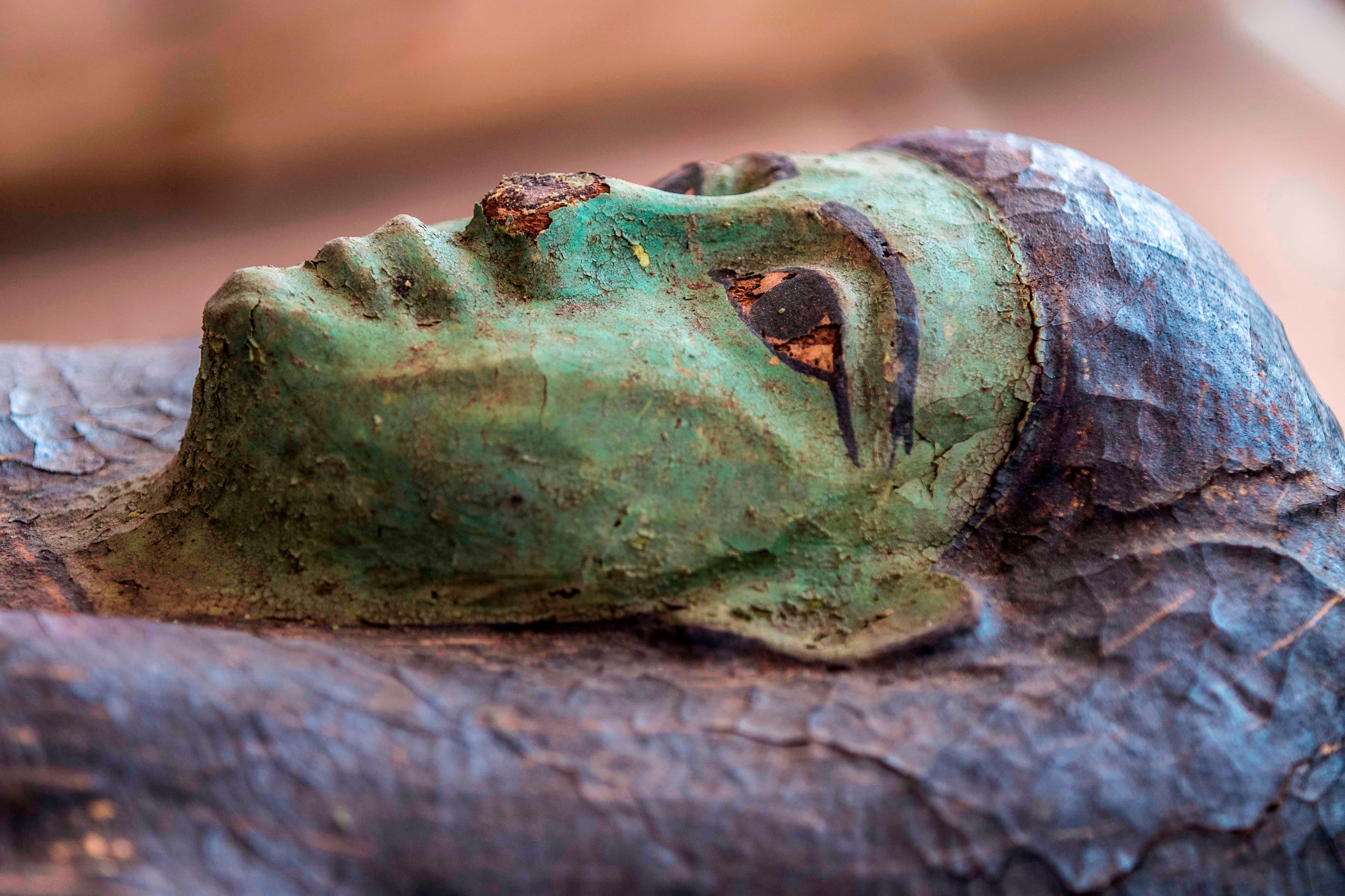 A picture taken on October 3, 2020 shows one of the sarcophaguses, excavated by the Egyptian archaeological mission which resulted in the discovery of a deep burial well with more than 59 human coffins closed for more than 2,500 years, displayed during a press conference  at the Saqqara necropolis, 30 kms south of the Egyptian capital Cairo. - They were unearthed south of Cairo in the sprawling burial ground of Saqqara, the necropolis of the ancient Egyptian capital of Memphis, a UNESCO World Heritage site. Their exteriors are covered in intricate designs in vibrant colours as well as hieroglyphic pictorials. (Photo by Khaled DESOUKI / AFP) (Photo by KHALED DESOUKI/AFP via Getty Images)