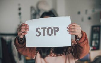 one person holding a banner with stop single word againd blue background