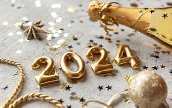 Golden color palette photo with new year 2024 numbers surrounded by confetti and decorations