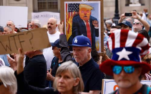 epa12461981 Members of the US Democratic Party living abroad carry placards as they take part in a protest against US President Trump and in defense of 'Democracy in the US', in downtown Barcelona, Spain, 18 October 2025.  EPA/Quique Garcia