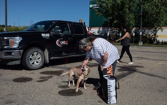 Hay River fire evacuee Yvette Bruneau pets the family dog after making their way to the evacuee centre in St. Albert, Alberta on Wednesday August 16, 2023. Photo by Jason Franson/CP/ABACAPRESS.COM