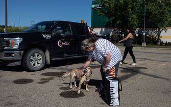 Hay River fire evacuee Yvette Bruneau pets the family dog after making their way to the evacuee centre in St. Albert, Alberta on Wednesday August 16, 2023. Photo by Jason Franson/CP/ABACAPRESS.COM