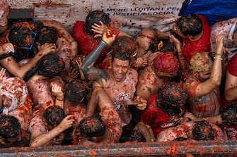 BUNOL, SPAIN - AUGUST 30: Revellers celebrate and throw tomatoes at each other as they participate in the annual Tomatina festival on August 30, 2023 in Bunol, Spain. Spain's tomato throwing party in the streets of Bunol, Valencia brings together almost 20,000 people, with some 150,000 kilos of tomatoes thrown each year, this year with a backdrop of high food prices affected by Spain's historic drought. (Photo by Zowy Voeten/Getty Images)