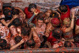 BUNOL, SPAIN - AUGUST 30: Revellers celebrate and throw tomatoes at each other as they participate in the annual Tomatina festival on August 30, 2023 in Bunol, Spain. Spain's tomato throwing party in the streets of Bunol, Valencia brings together almost 20,000 people, with some 150,000 kilos of tomatoes thrown each year, this year with a backdrop of high food prices affected by Spain's historic drought. (Photo by Zowy Voeten/Getty Images)