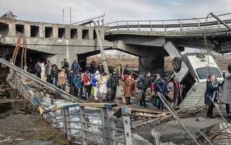 epa09812969 Residents cross the destroyed bridge as they flee from the frontline town of Irpin, Kyiv (Kiev) region, Ukraine, 09 March 2022. Irpin, the town which is located near Kyiv city had heavy fightings for almost a week between Ukrainian and Russian militaries forcing thousands of people to escape from the town.  EPA/MIKHAIL PALINCHAK