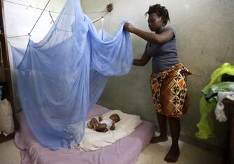 epa05925294 Zamble Lou Irie Sabine, 28 years old, installs a mosquito net on her three month old child Yao Melvin, in Abidjan, Ivory Coast, 24 April 2017. World Malaria Day is observed on 25 April each year to recognize the global efforts to control Malaria, it was established in May 2007 by the World Health Organization (WHO).  EPA/LEGNAN KOULA