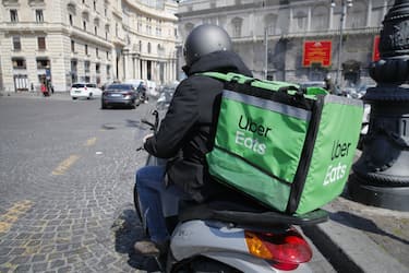 NAPLES, CAMPANIA, ITALY - 2021/03/26: An Uber Eats delivery driver rides his scooter on street during the COVID-19 Coronavirus pandemic in Naples, Campania regione, southern Italy. Delivery services have seen their activities increased due to the mandatory lockdown imposed by the government to help curve down COVID-19 contagion. (Photo by Salvatore Laporta/KONTROLAB/LightRocket via Getty Images)