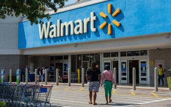 People near Walmart store. Walmart is the world's third largest public corporation that runs chains of department stores. Coronavirus time.