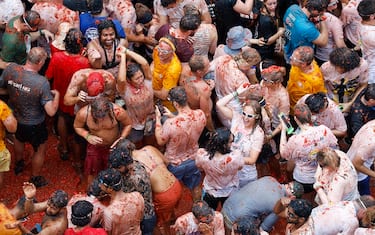 epa10828458 People participate in La Tomatina, a traditional and world-wide known tomato fight festival, in Bunol, Valencia province, eastern Spain, 30 August 2023. As every year on the last Wednesday of August, thousands of people visit the small village of Bunol to attend the Tomatina, a battle in which tons of ripe tomatoes are used to throw at each other.  EPA/MIGUEL ANGEL POLO