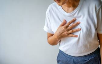 Woman suffering from chest pain heart attack. Healthcare and medical concept.